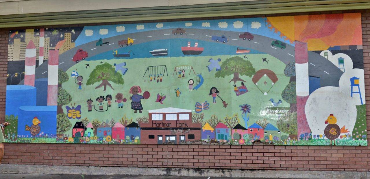 mural of a neighborhood surrounded by smokestacks, flares, and tanks