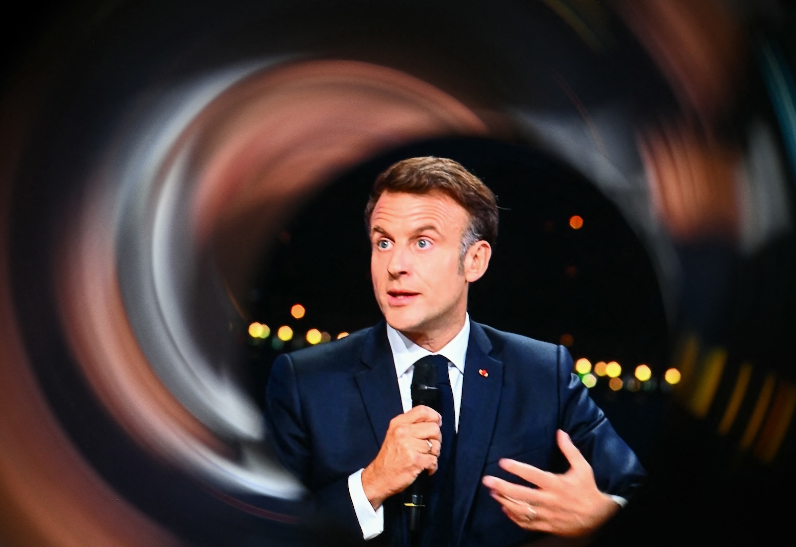 France's president, Emmanuel Macron, holding a microphone.