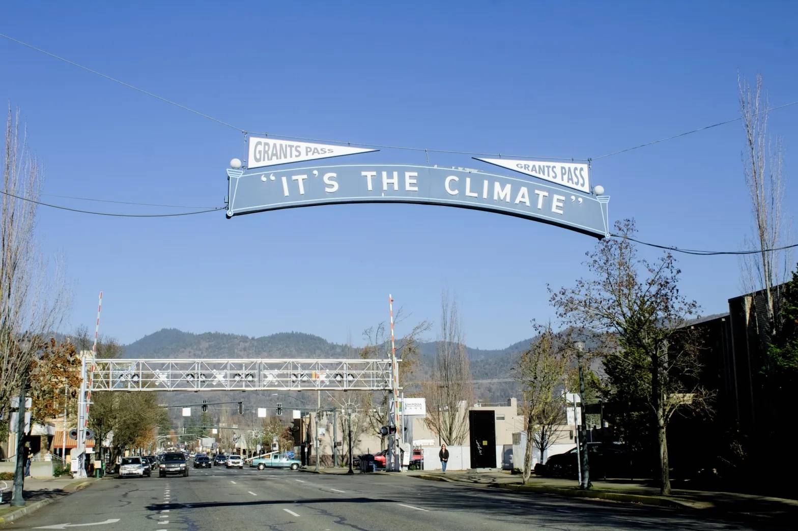 A blue "It's the Climate" sign stretches across a quiet street.