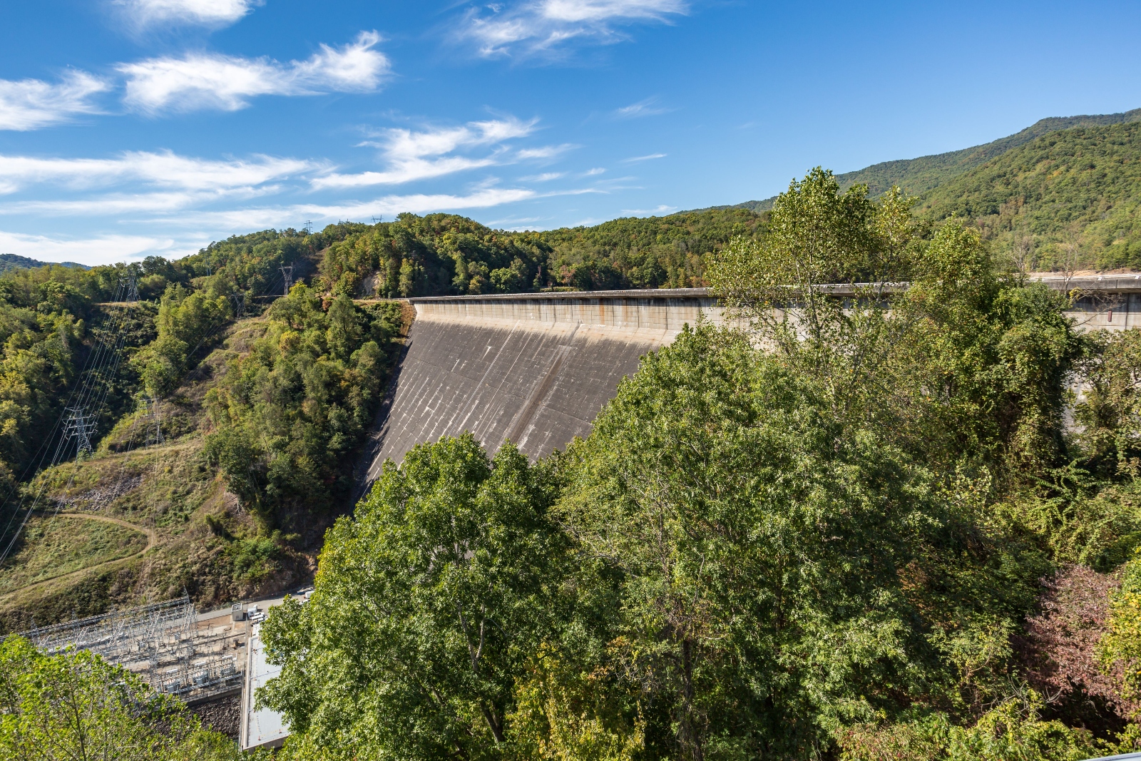 Aerial view of the Fontana dam on the Little Tennessee River, surrounded by lush green foliage and hills