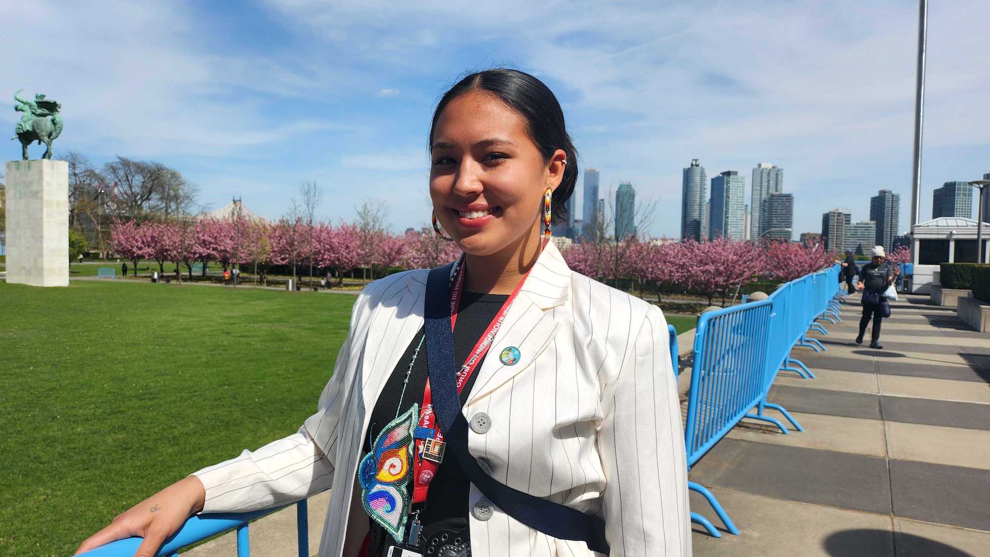 A woman wearing a UN badge stands on a bridge
