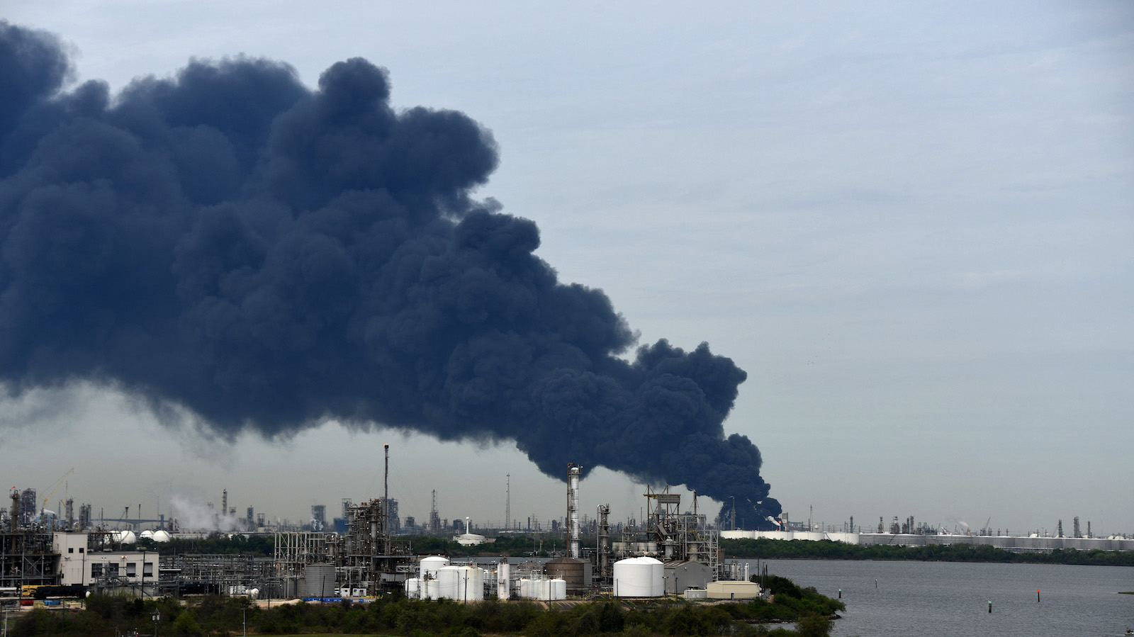 Black smoke billows across the sky as a chemical storage site burns in a fire.